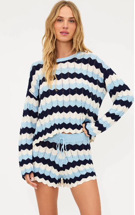 Woman wearing a striped sweater and shorts on a white background